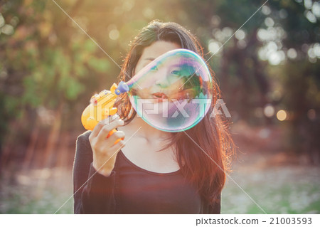 Beautiful young woman blowing bubble in sunlight. Beautiful young woman blowing bubble in sunlight. 21003593