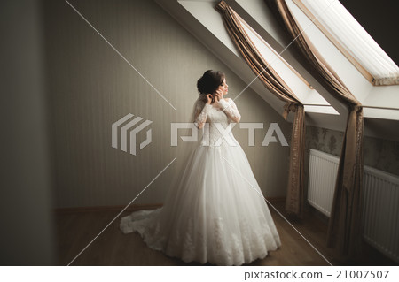 Luxury bride in white dress posing while preparing Luxury bride in white dress posing while preparing 21007507