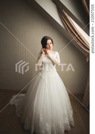 Luxury bride in white dress posing while preparing Luxury bride in white dress posing while preparing 21007508