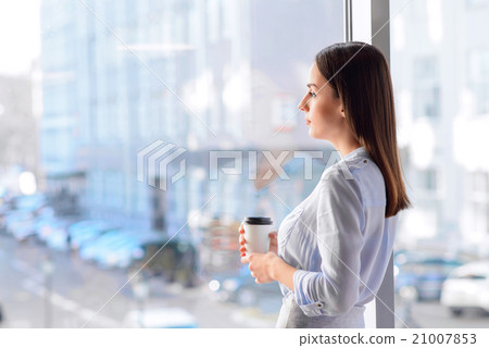 Pleasant sad woman standing near window Pleasant sad woman standing near window 21007853