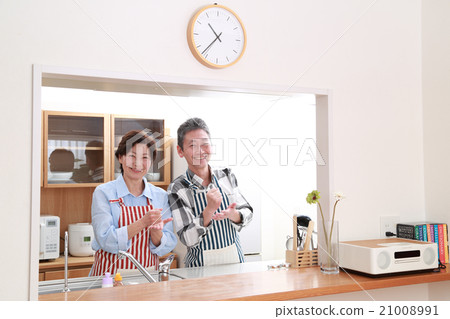 A couple in their 50s standing in a friendly kitchen 21008991
