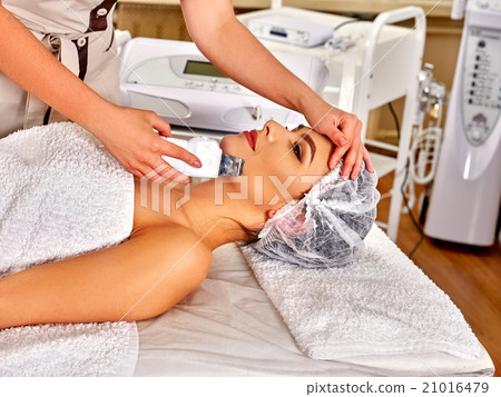 Woman receiving electric facial peeling massage. Woman receiving electric facial peeling massage. 21016479