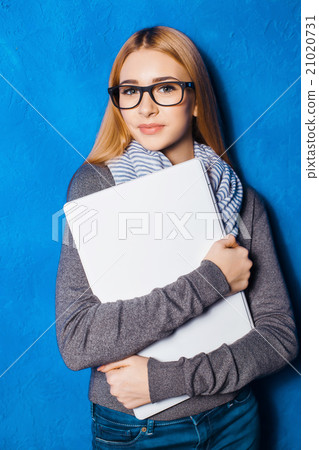 Cute girl against blue wall 21020731
