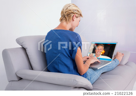 Composite image of blonde woman using her laptop on the couch 21022126
