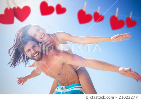 Composite image of handsome man giving piggy back to his girlfri Composite image of handsome man giving piggy back to his girlfri 21022277