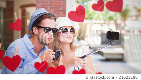 Composite image of cute couple taking a selfie with selfie stick 21023186