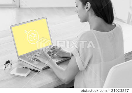 Composite image of businesswoman using laptop at desk in creativ Composite image of businesswoman using laptop at desk in creativ 21023277