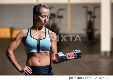 Composite image of fit woman exercising by lifting dumbbell Composite image of fit woman exercising by lifting dumbbell 21023280