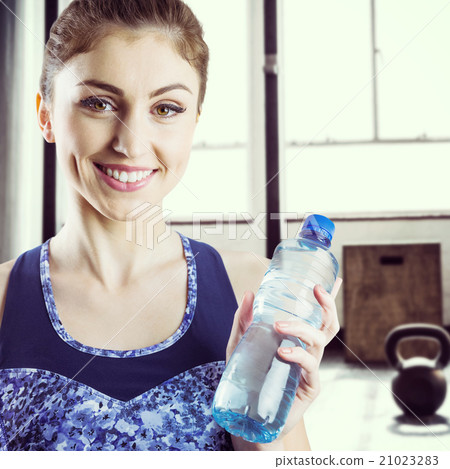Composite image of fit brunette holding water bottle 21023283