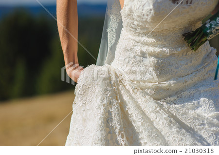Bride holds the magnificent dress 21030318