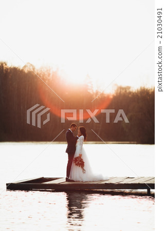 Elegant beautiful wedding couple posing near a Elegant beautiful wedding couple posing near a 21030491