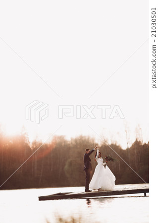 Elegant beautiful wedding couple posing near a Elegant beautiful wedding couple posing near a 21030501