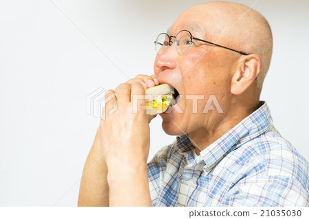 Senior smiley eating hot sandwich 21035030