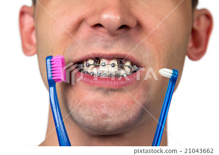 Young man with two toothbrushes Young man with two toothbrushes 21043662