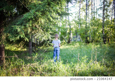 Young guy  standing in a forest on the grass 21064147