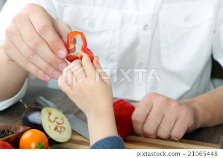 Man giving paprika to daughter. Cooking concept 21065448