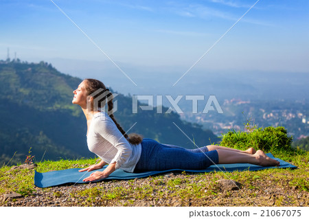 Woman practices yoga asana bhujangasana cobra pose 21067075