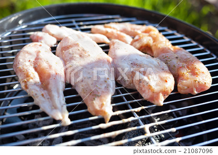 Raw chicken fillet breast cooking on barbeque grid 21087096