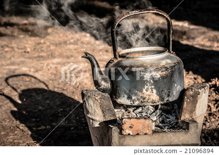 old aluminium kettle on stove, is boiling water. 21096894