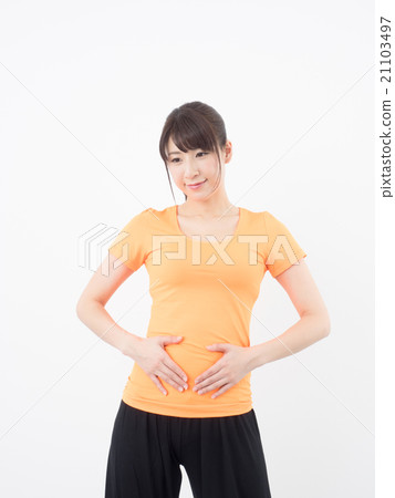 A woman putting her hands on her stomach A woman putting her hands on her stomach 21103497