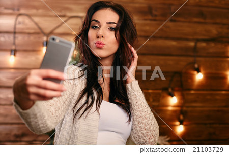 Portrait of a beautiful brunette taking a selfie 21103729