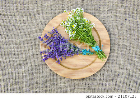 Chamomile and hyssop on wooden plate 21107123