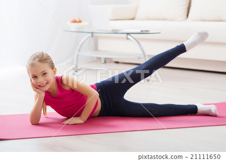 Girl doing exercises lying on the mat Girl doing exercises lying on the mat 21111650