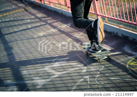 Young male skateboarder cruising on bridge 21114997