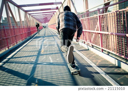 Skateboarder cruise on bridge Skateboarder cruise on bridge 21115010