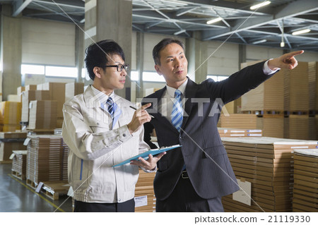 工作的兩個人在企業圖像倉庫裡穿衣裳和衣服 工作的兩個人在企業圖像倉庫裡穿衣裳和衣服 21119330
