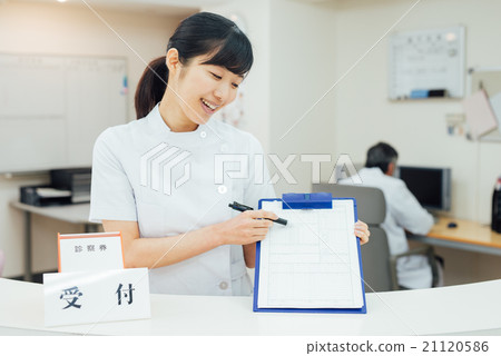 Doctor and nurse standing at reception 21120586