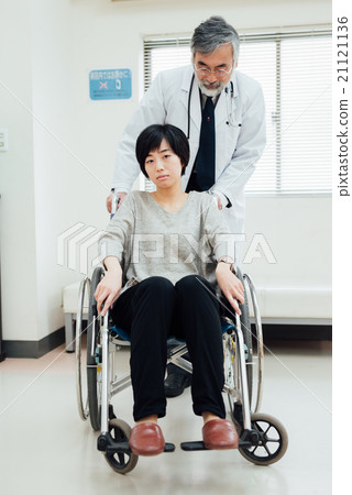 Doctor pushing patient's wheelchair Doctor pushing patient's wheelchair 21121136