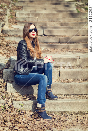 Young woman in leather jacket resting on stairs Young woman in leather jacket resting on stairs 21122624