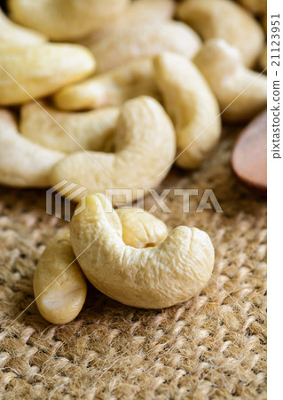 Raw cashew nuts with wooden spoon on sackcloth 21123951