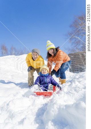 三個家庭在雪地裡的公園裡玩雪橇 21126855