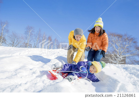 Three families playing sledding in a park in the snow 21126861