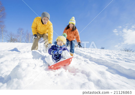 Three families playing sledding in a park in the snow Three families playing sledding in a park in the snow 21126863