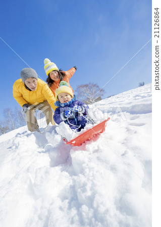 Three families playing sledding in a park in the snow 21126864