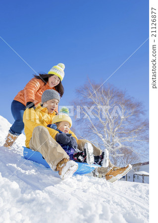 三個家庭在雪地裡的公園裡玩雪橇 21126877