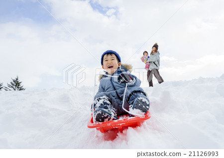 Parents playing with sledding in a park in the snow Parents playing with sledding in a park in the snow 21126993