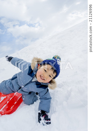 一個男孩在雪地公園玩雪橇 21126996