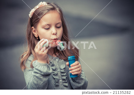 funny lovely little girl blowing soap bubble funny lovely little girl blowing soap bubble 21135282