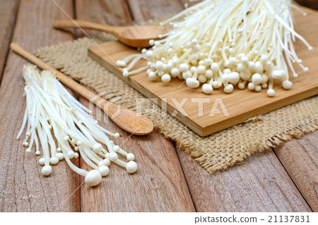 图库照片: enoki mushroom with spoon on wooden table