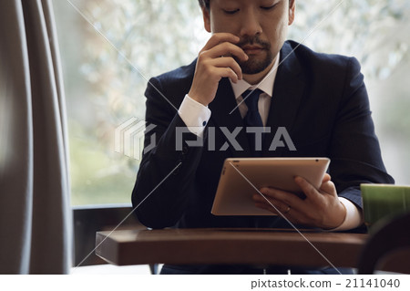 A businessman looking at a tablet 21141040