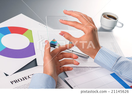 Lady's hands touching transparent smartphone.  21145626