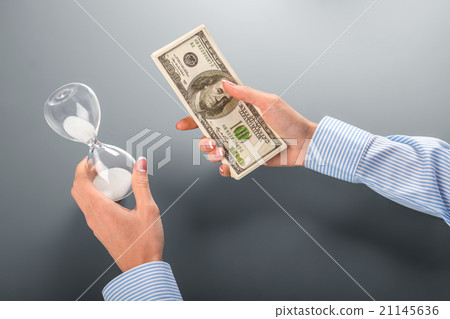 Businesswoman holding money and hourglass. Businesswoman holding money and hourglass. 21145636