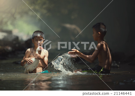 boys playing water splash with white duck on creek boys playing water splash with white duck on creek 21146441