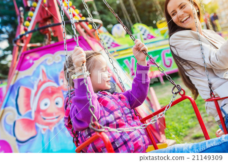 Mother and daughter at fun fair, chain swing ride 21149309