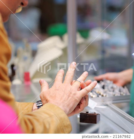 Man trying wedding rings at a jeweller 21167982