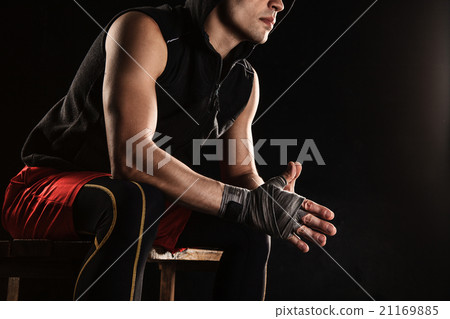 The muscular man sitting and resting on black The muscular man sitting and resting on black 21169885